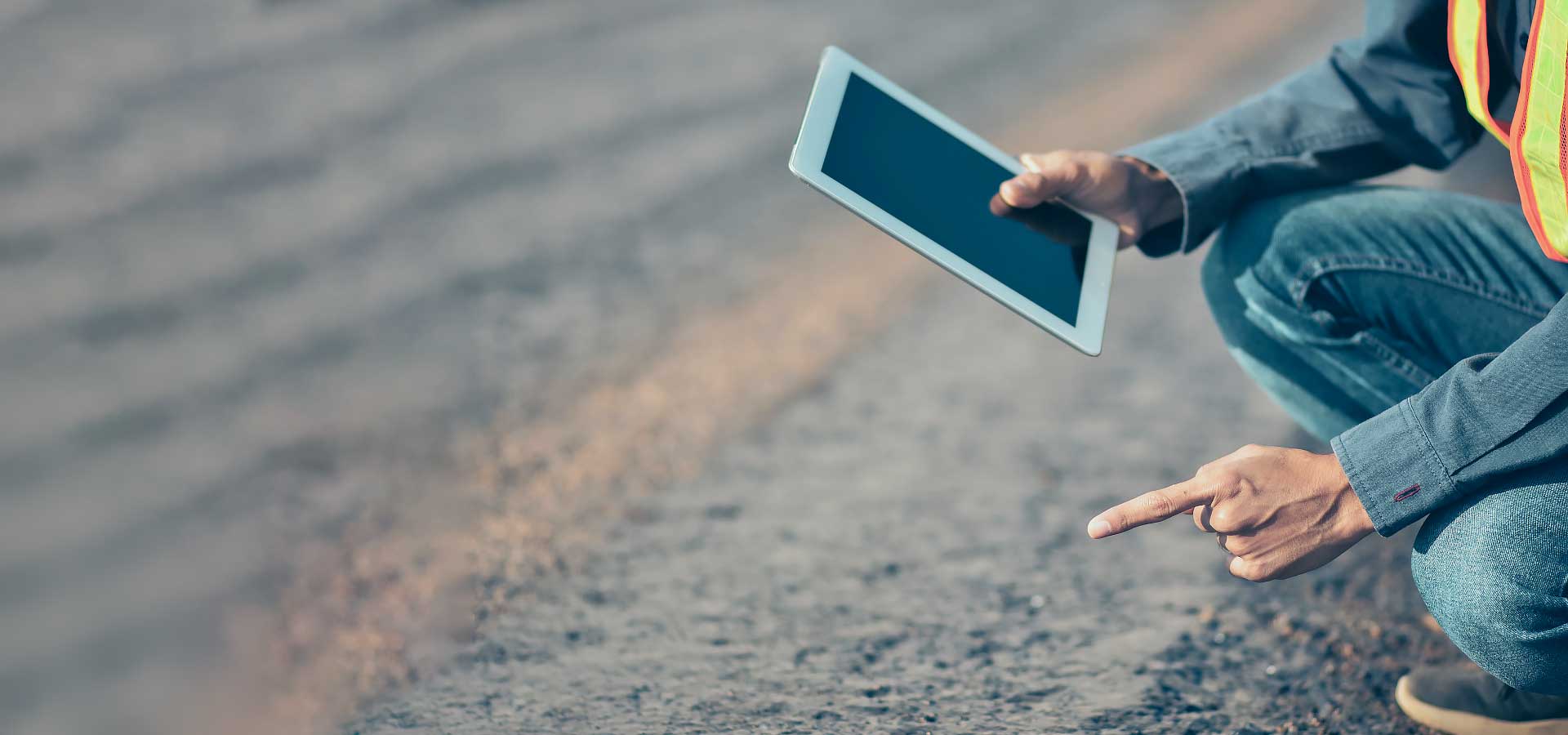 Roads worker holding a tablet managing pavement